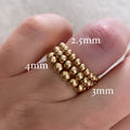 Barbel gold-filled bead rings stacked on hand with sizing – Omasi Collection
