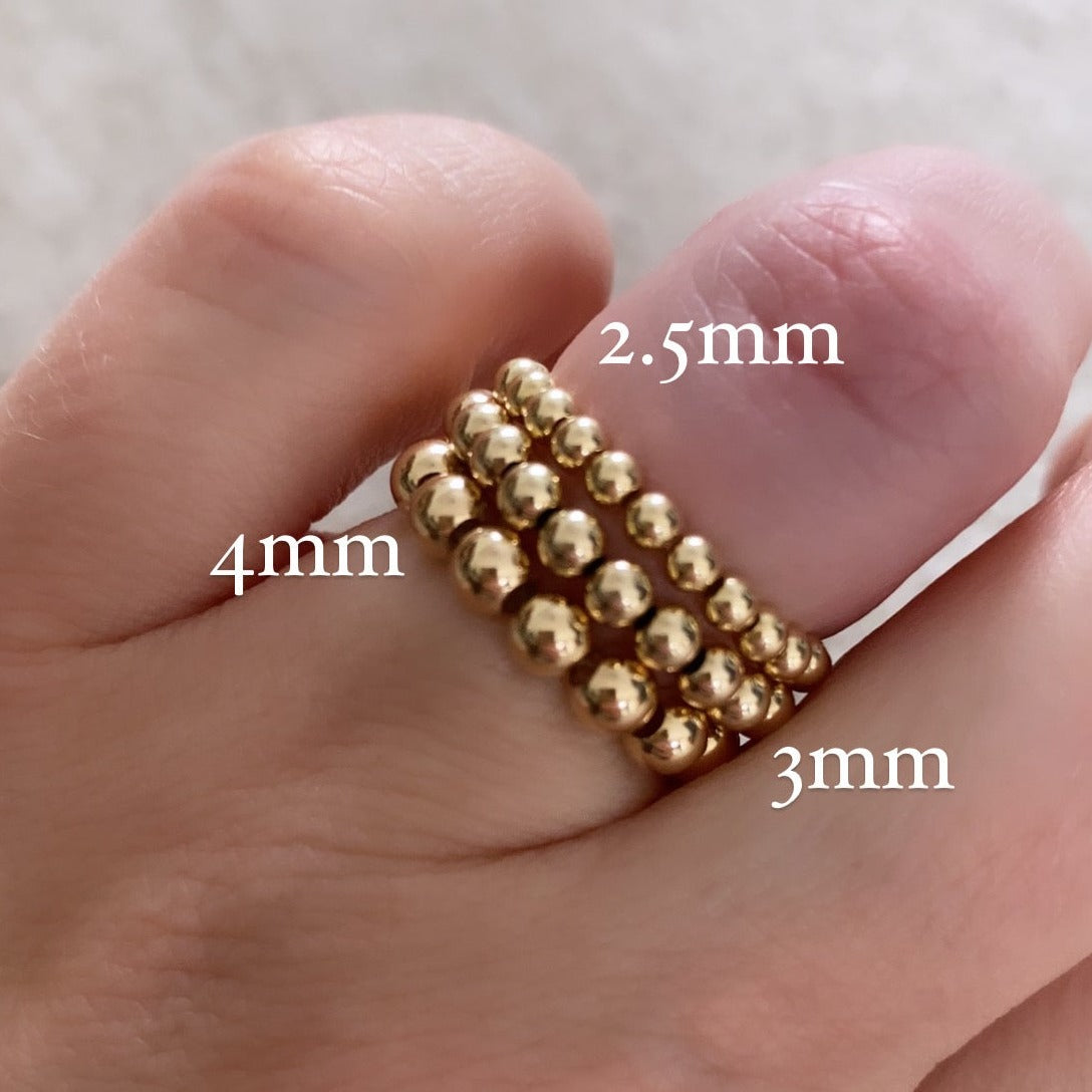 Barbel gold-filled bead rings stacked on hand with sizing – Omasi Collection