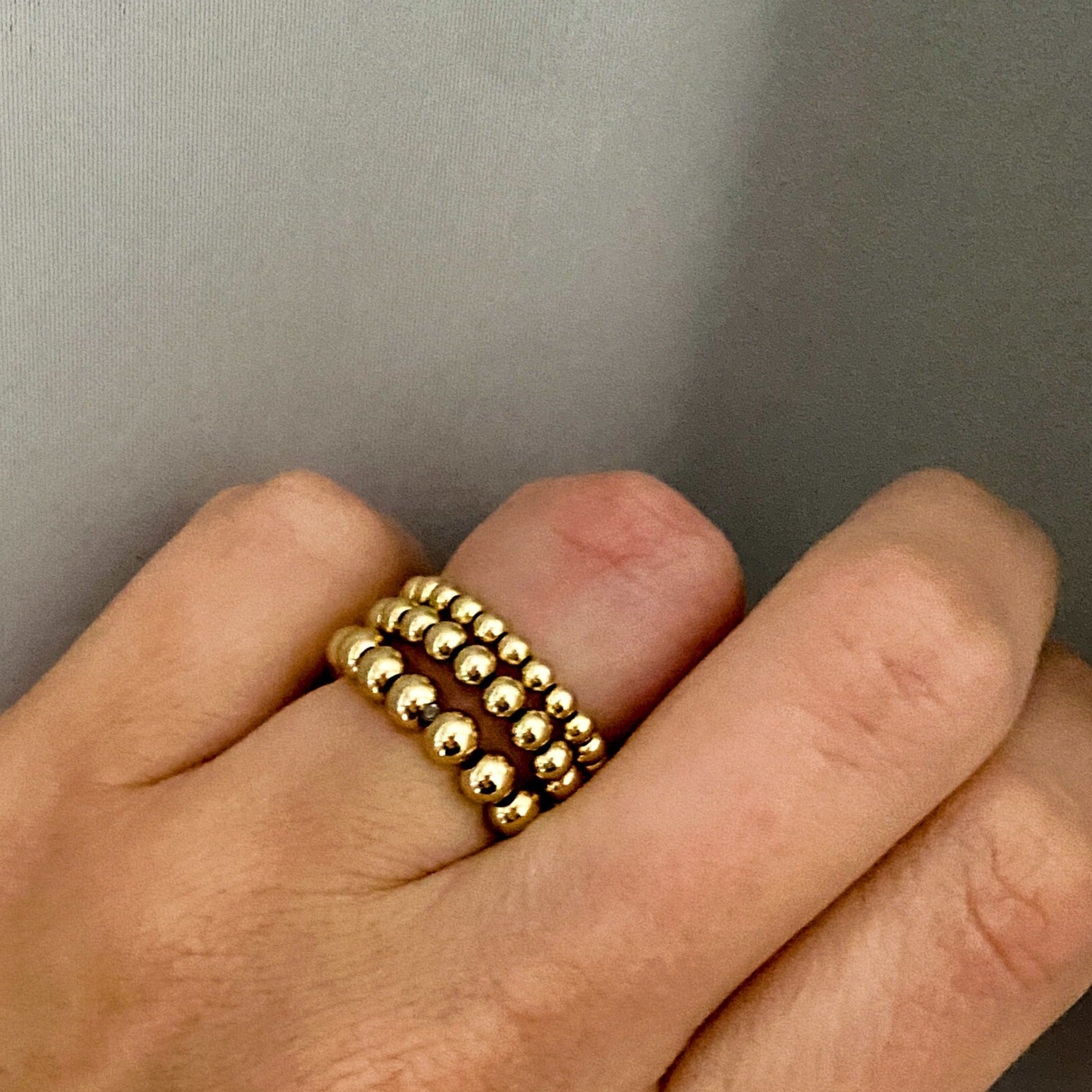Barbel gold-filled bead rings stacked on hand – Omasi Collection