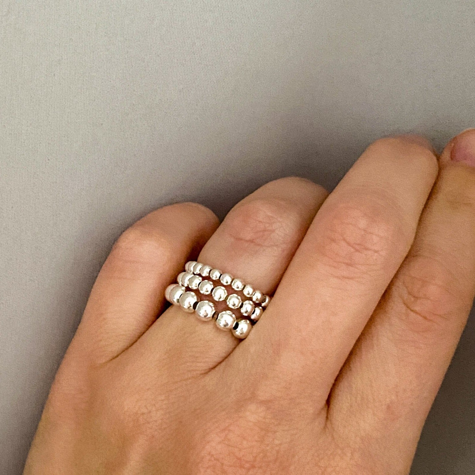 Barbel silver bead rings stacked on hand – Omasi Collection