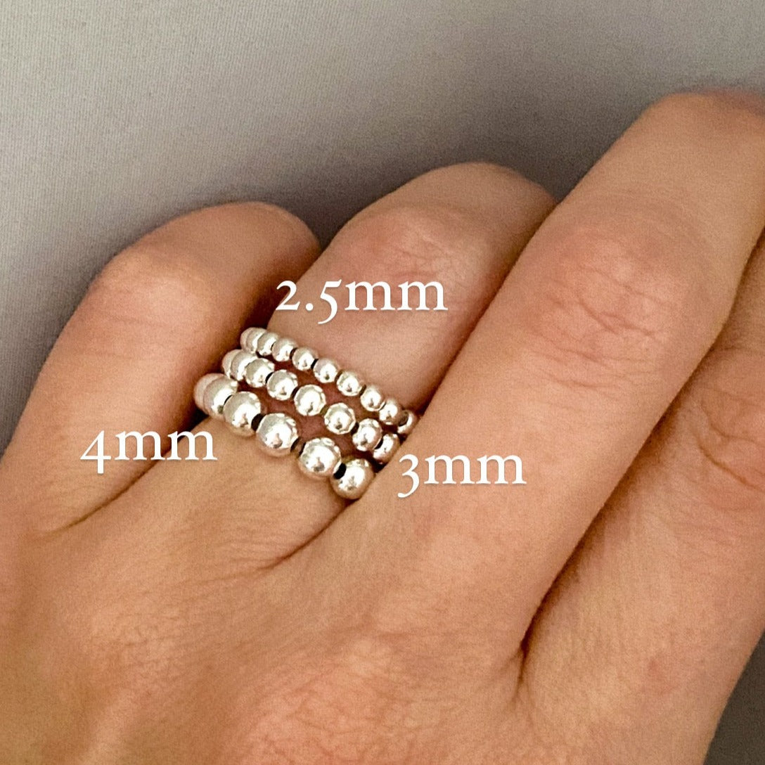 Barbel silver bead rings stacked on hand with sizing – Omasi Collection