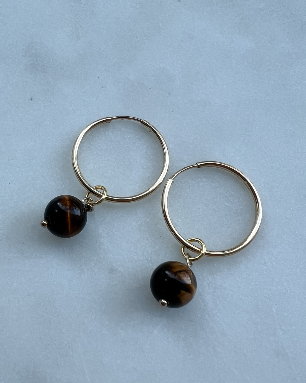 Gold-filled Tiger-eye Freya Hoop Earring flat lay – handmade minimalist jewellery Finland