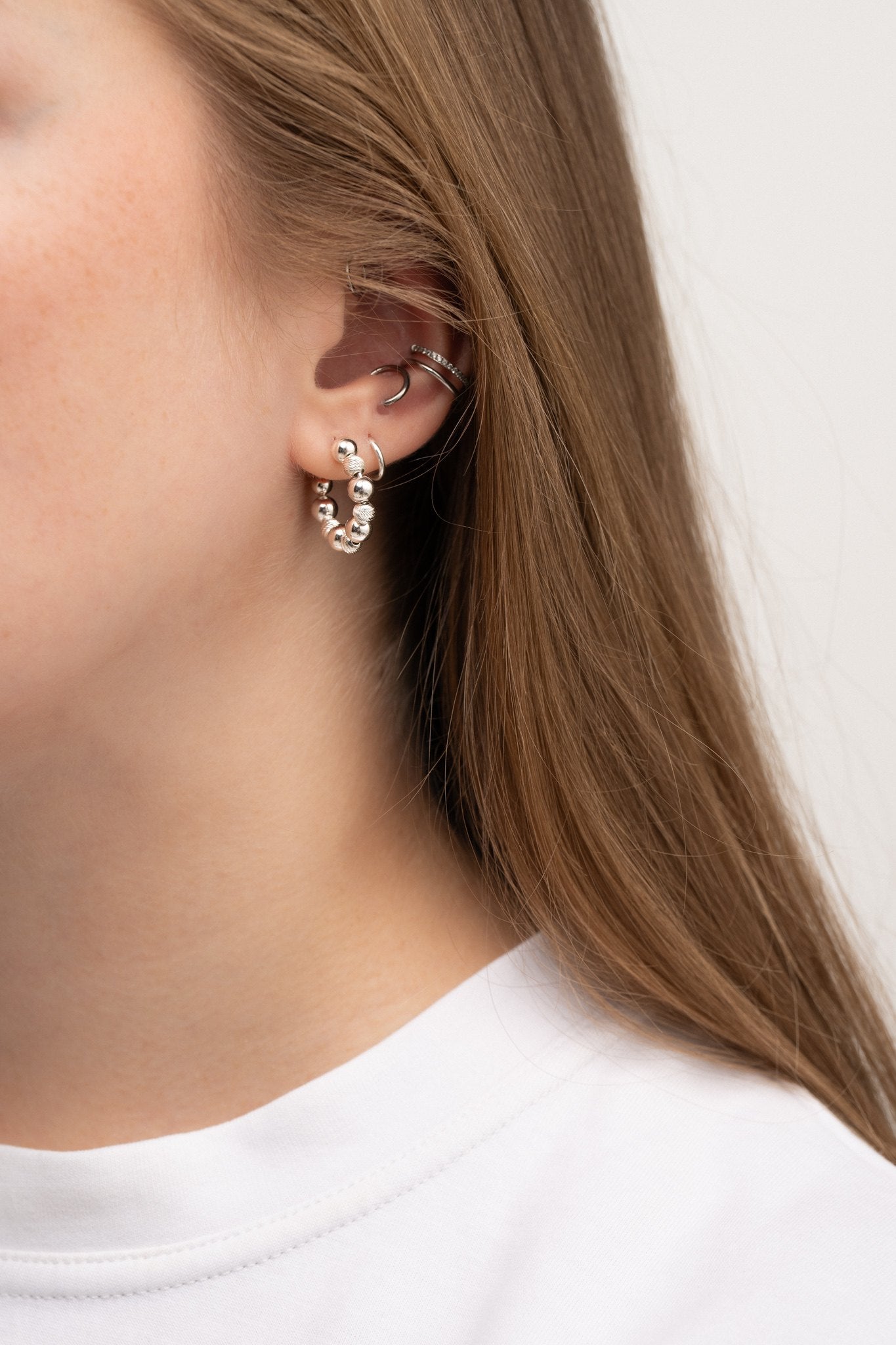 Ilona c-hoop silver earrings on model close up