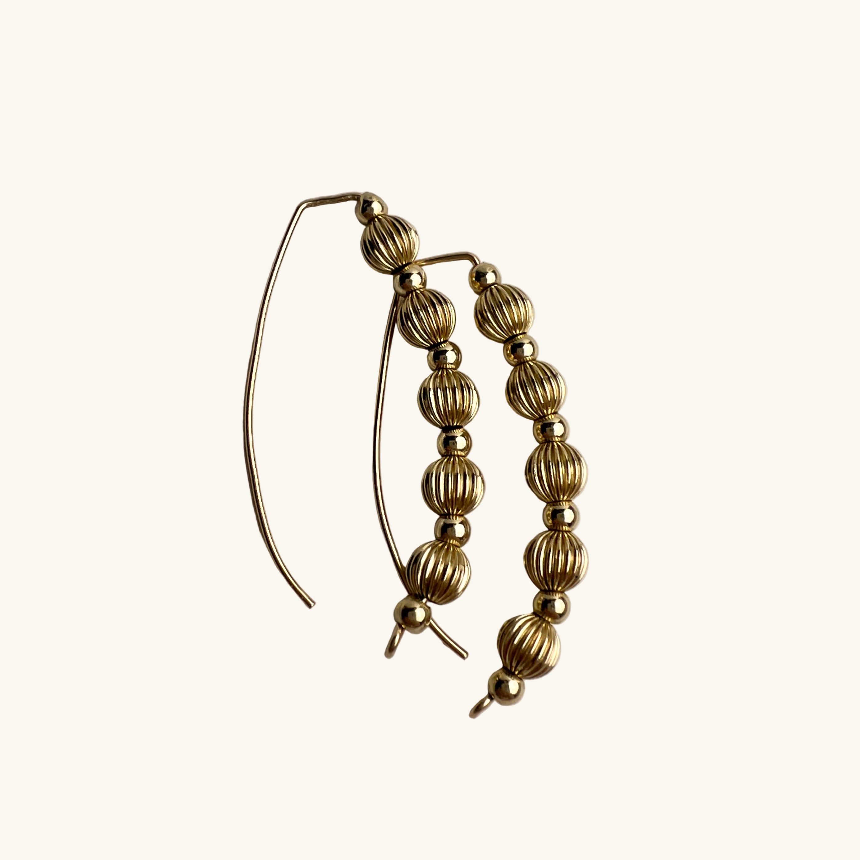 Livia wire earrings gold-filled with corrugated and smooth beads flat lay – Omasi Collection