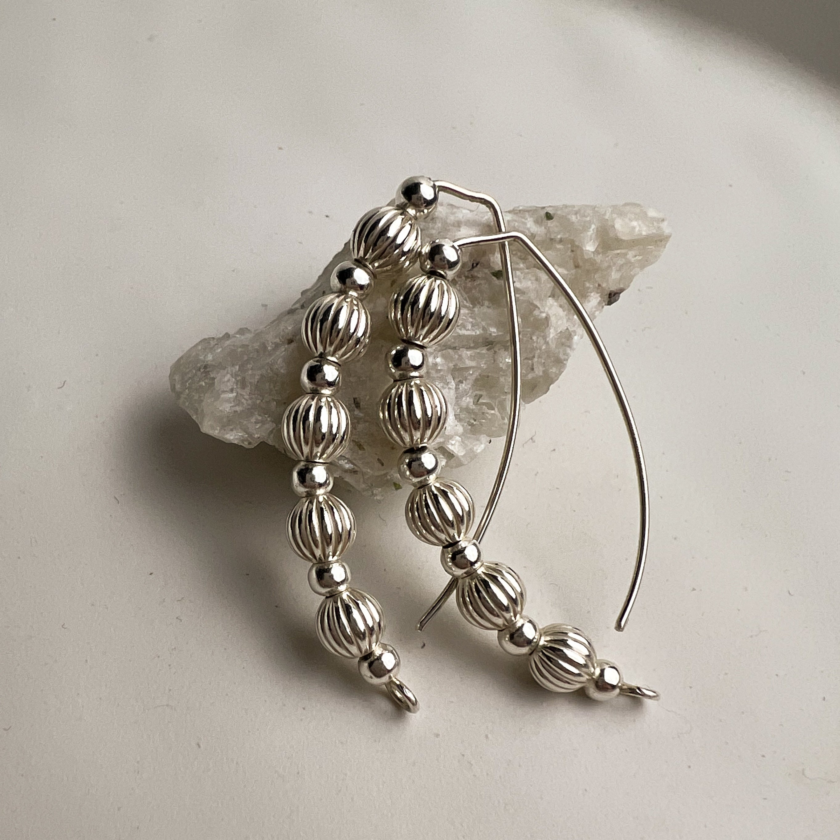 Livia wire earrings silver with corrugated and smooth beads flat lay – Omasi Collection