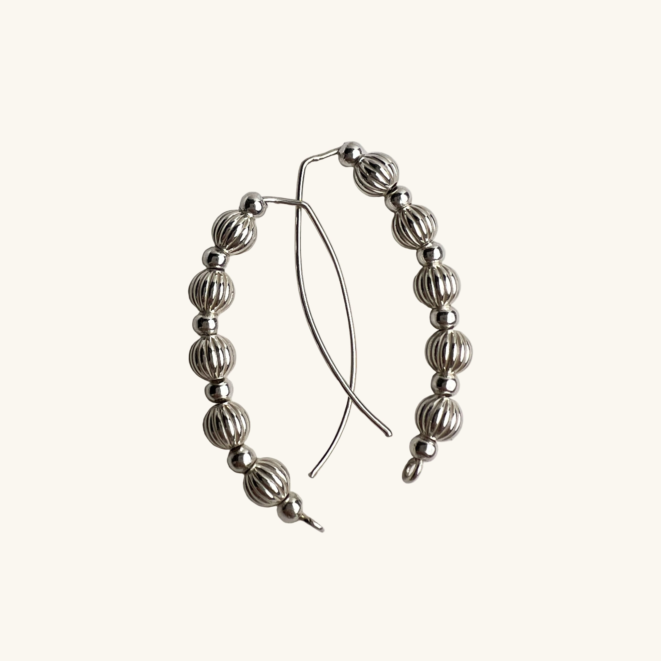 Livia wire earrings silver with corrugated and smooth beads flat lay2 – Omasi Collection