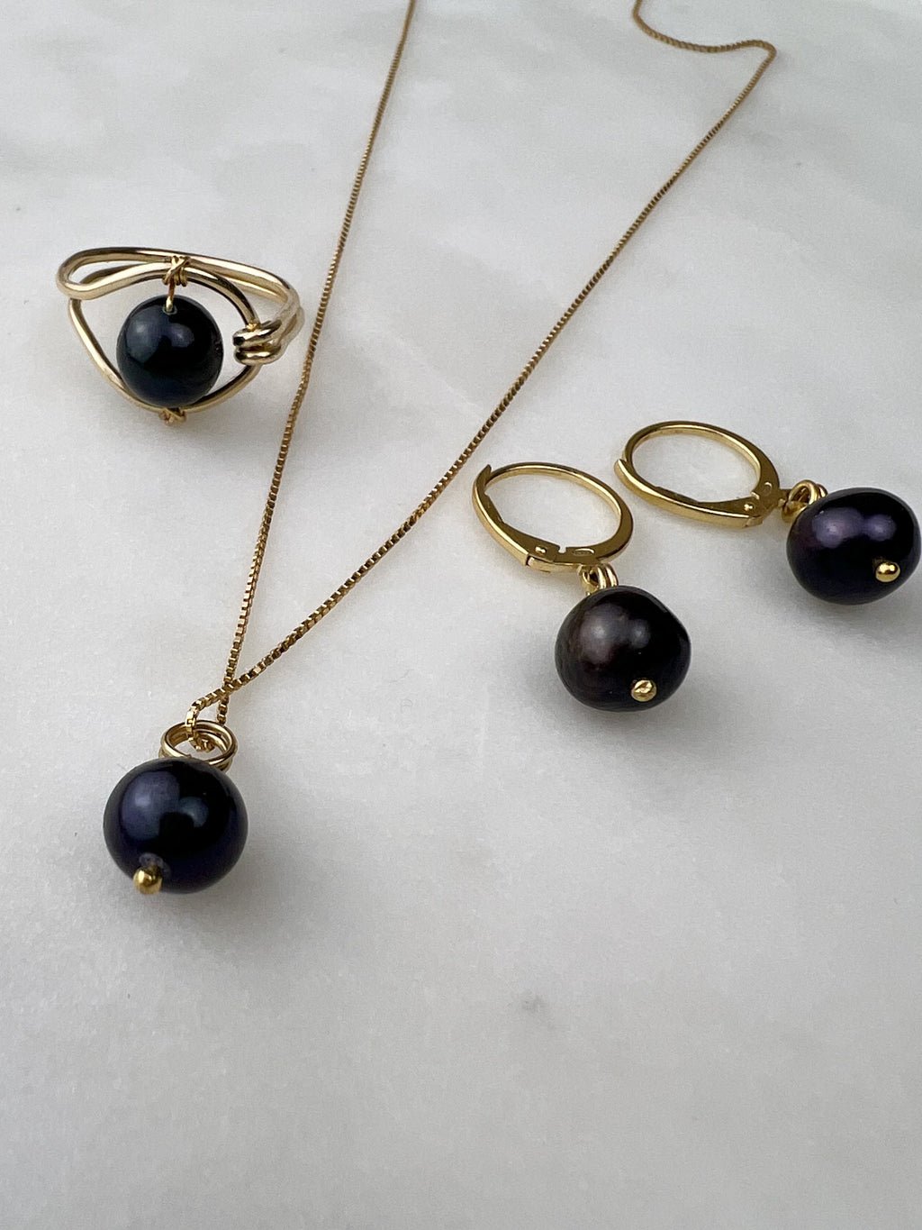 Luna black pearl necklace ring earrings flat lay – Omasi Collection
