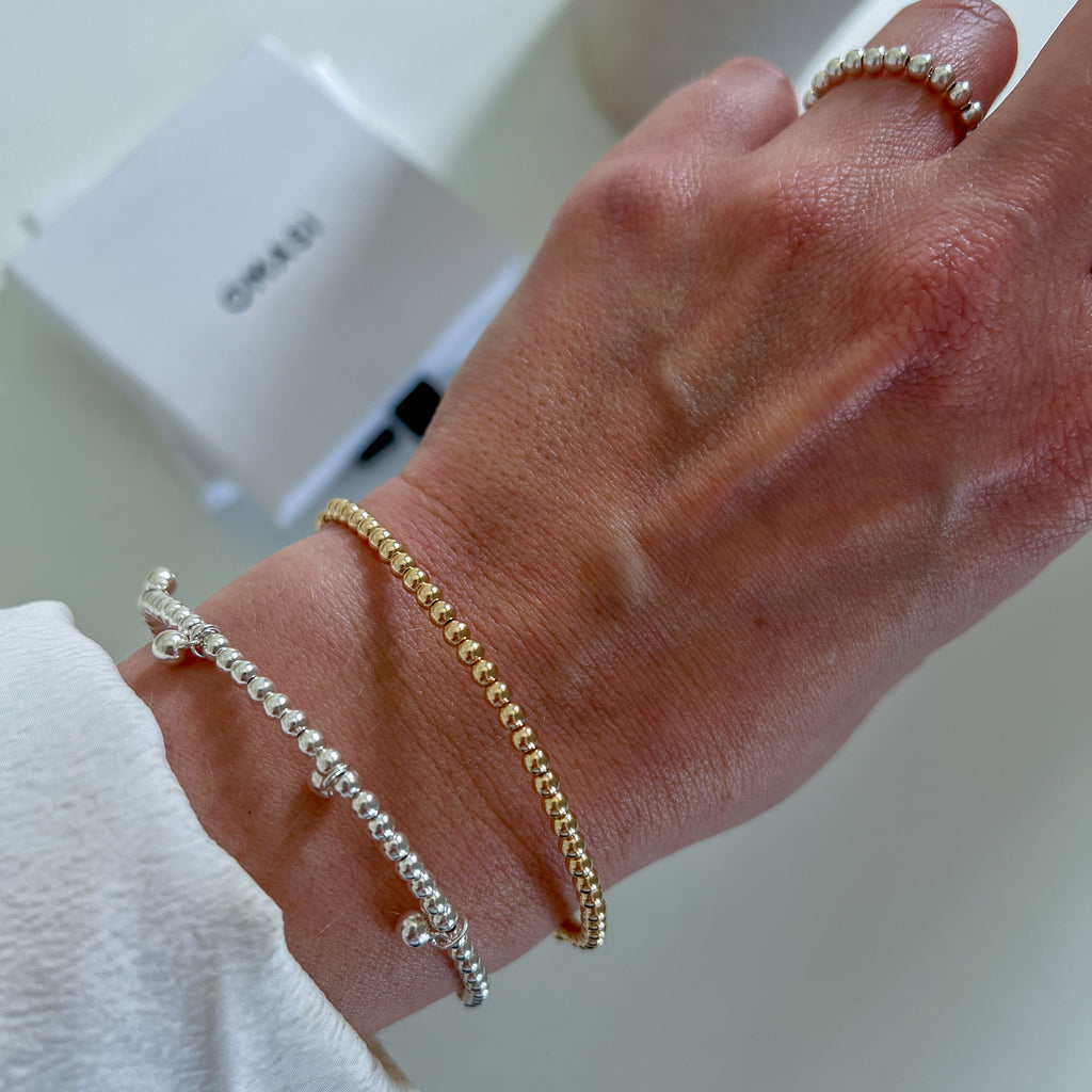 Melia silver bracelet stacked with Aura gold bracelet on wrist – Omasi Collection