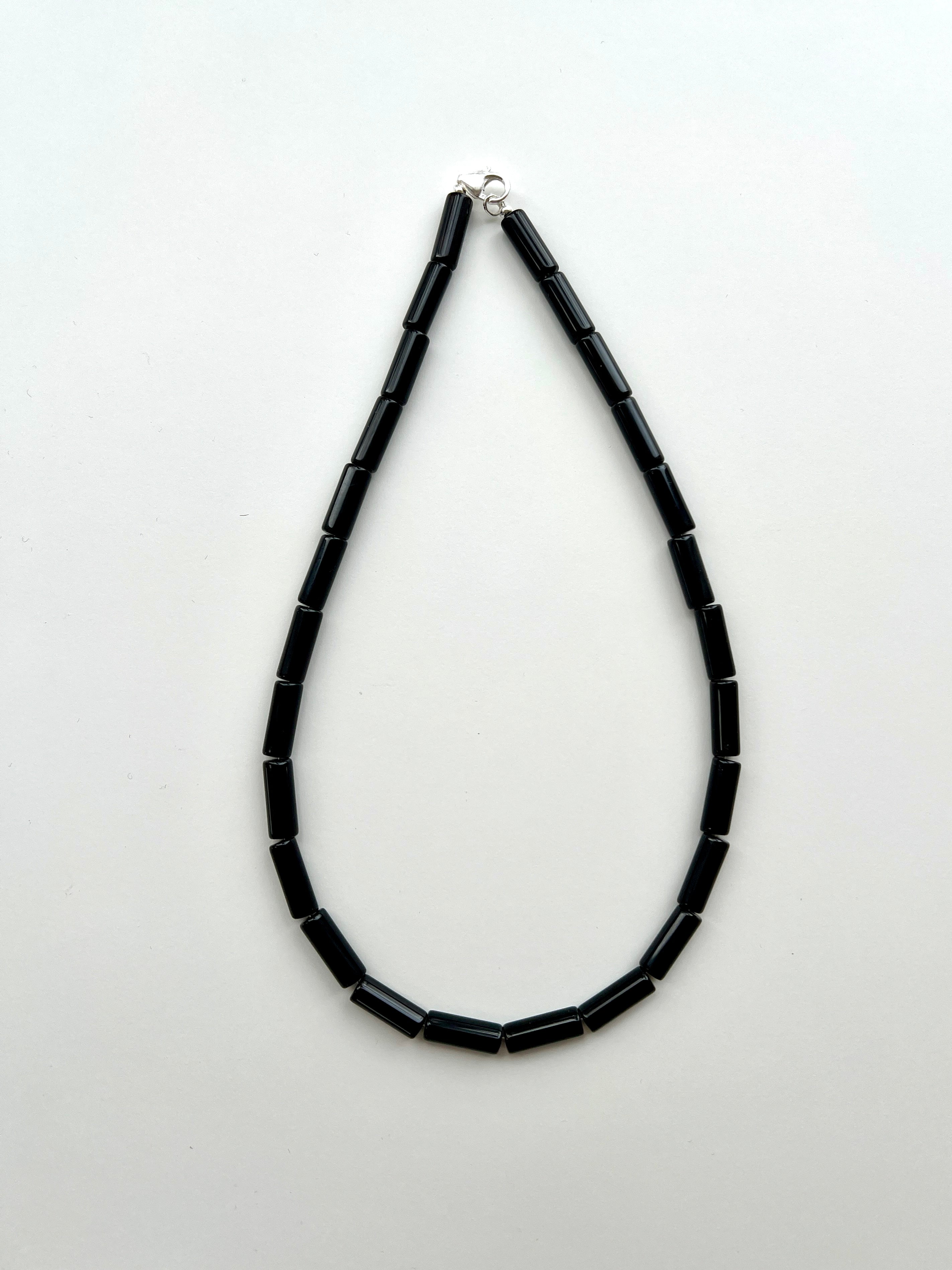 Sterling silver Linea necklace flat lay – onyx pendant Omasi Collection