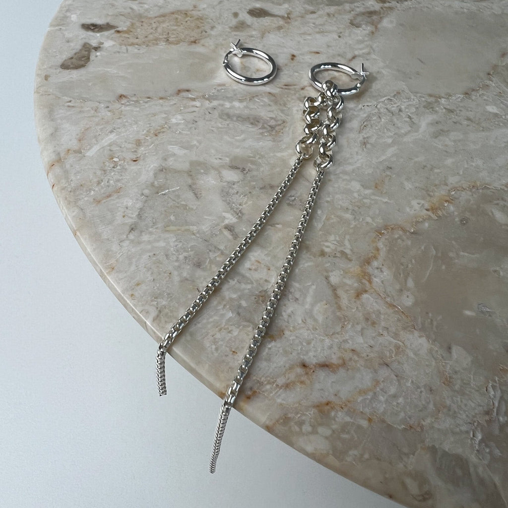 Vela asymmetric sterling silver earrings flat lay – Omasi Collection Finland
