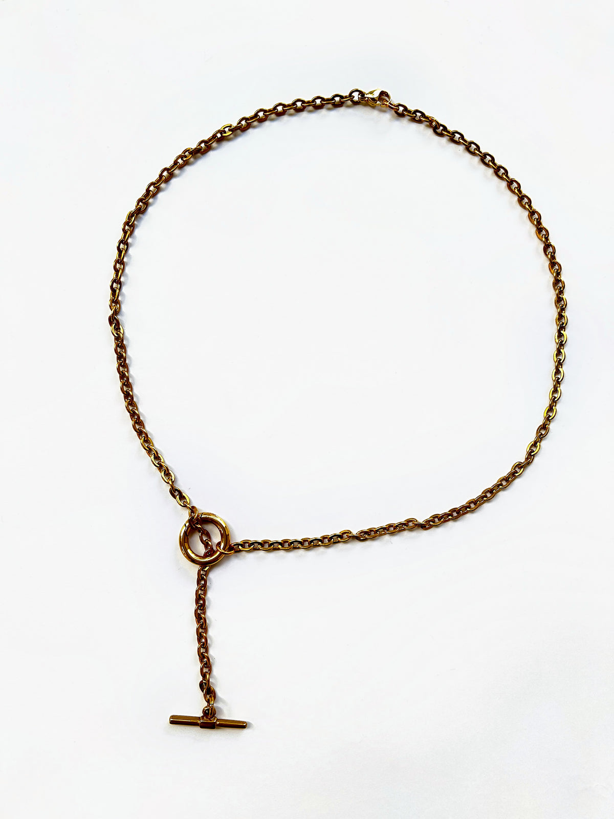 Mova gold tone loop necklace, adjustable T-bar lariat in nickel-free surgical steel, flat lay – Omasi Collection