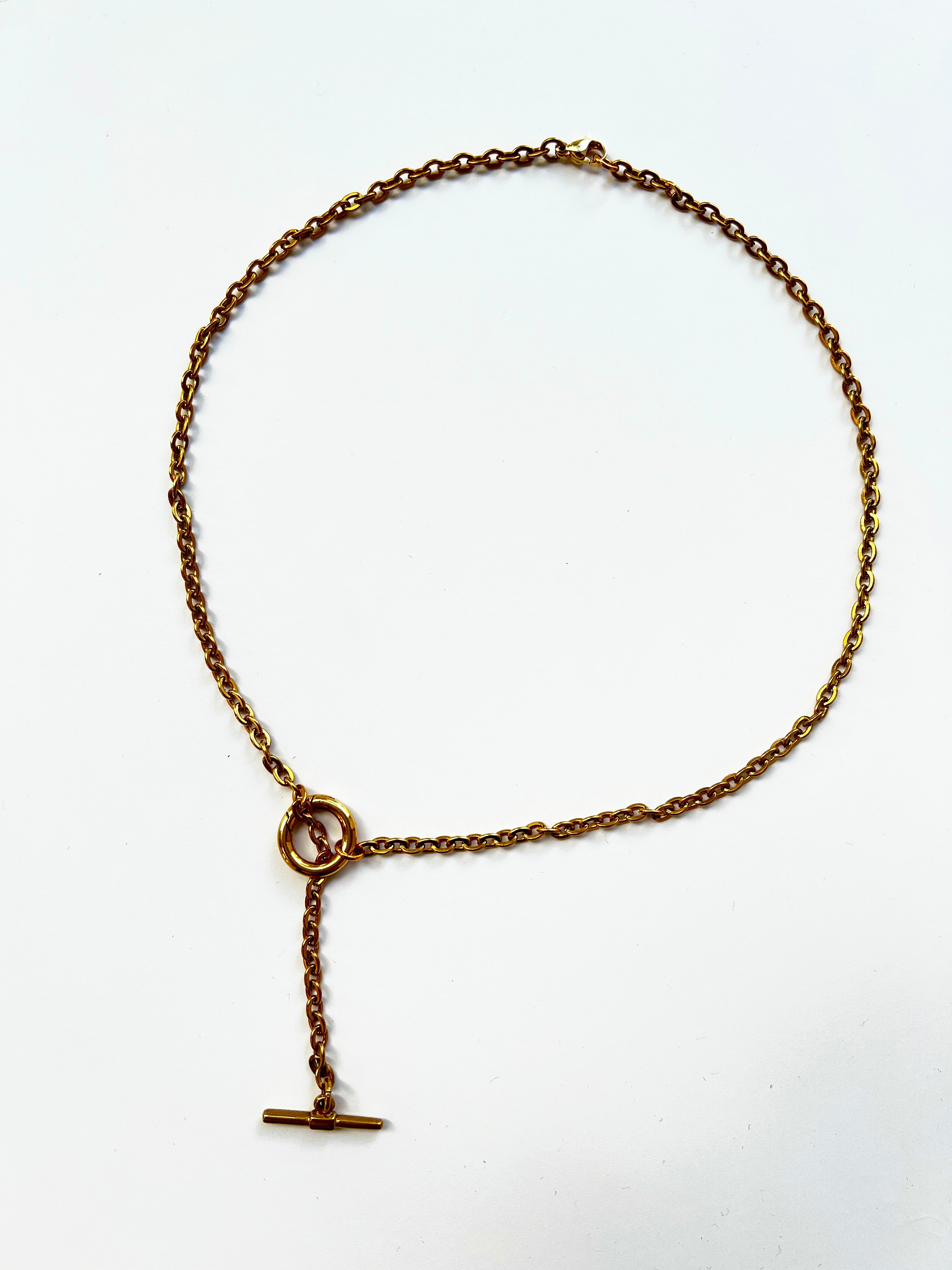 Mova gold tone loop necklace, adjustable T-bar lariat in nickel-free surgical steel, flat lay – Omasi Collection