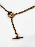 Mova gold tone loop necklace, close-up of the ring and T-bar drop in nickel-free surgical steel – Omasi Collection
