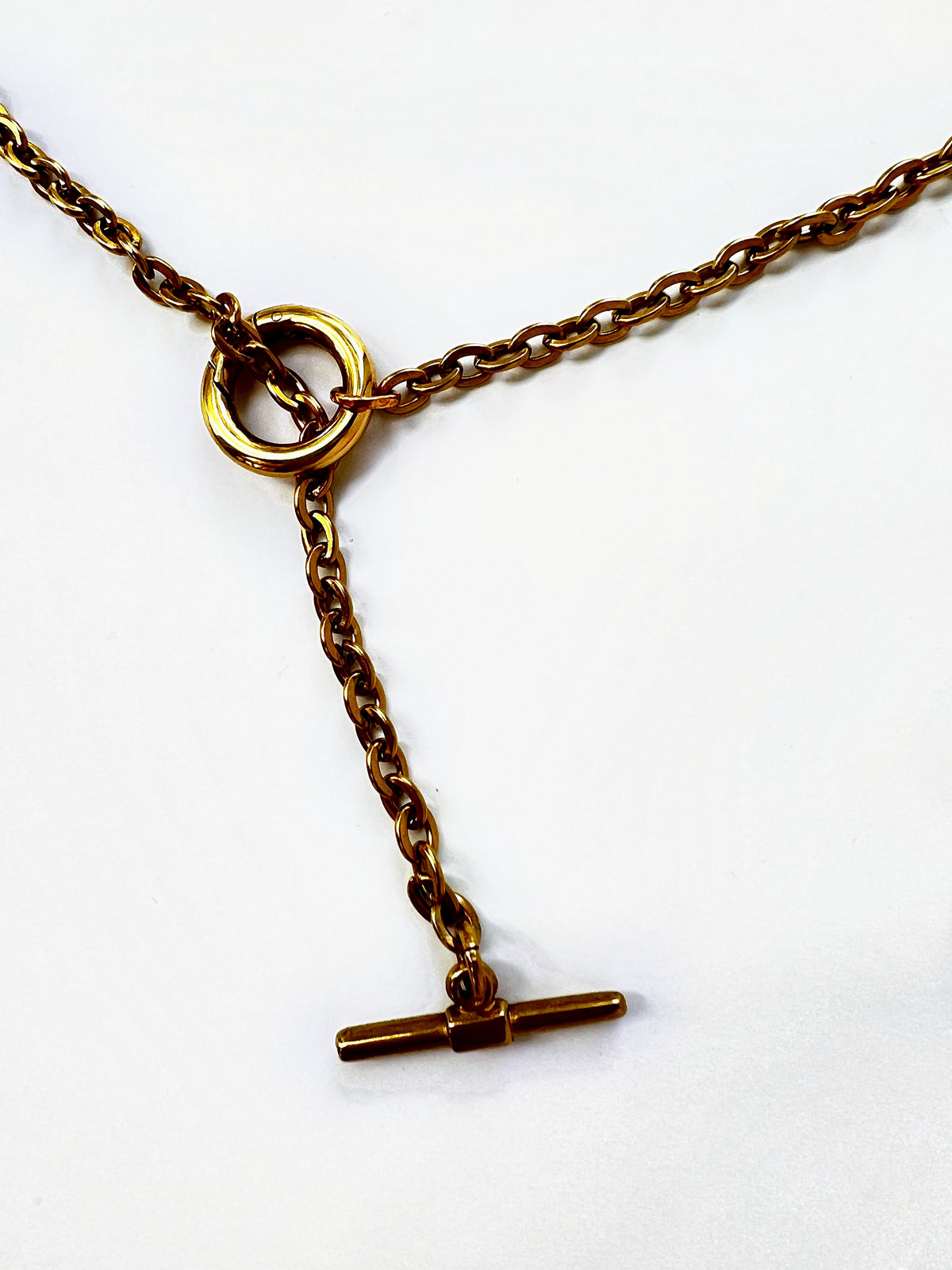 Mova gold tone loop necklace, close-up of the ring and T-bar drop in nickel-free surgical steel – Omasi Collection