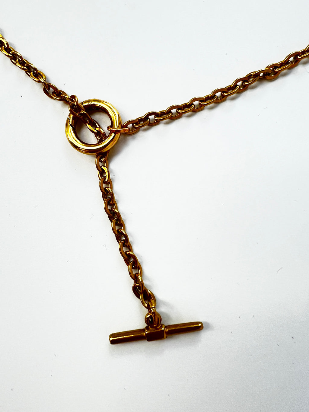 Mova gold tone loop necklace, close-up of the ring and T-bar drop in nickel-free surgical steel – Omasi Collection