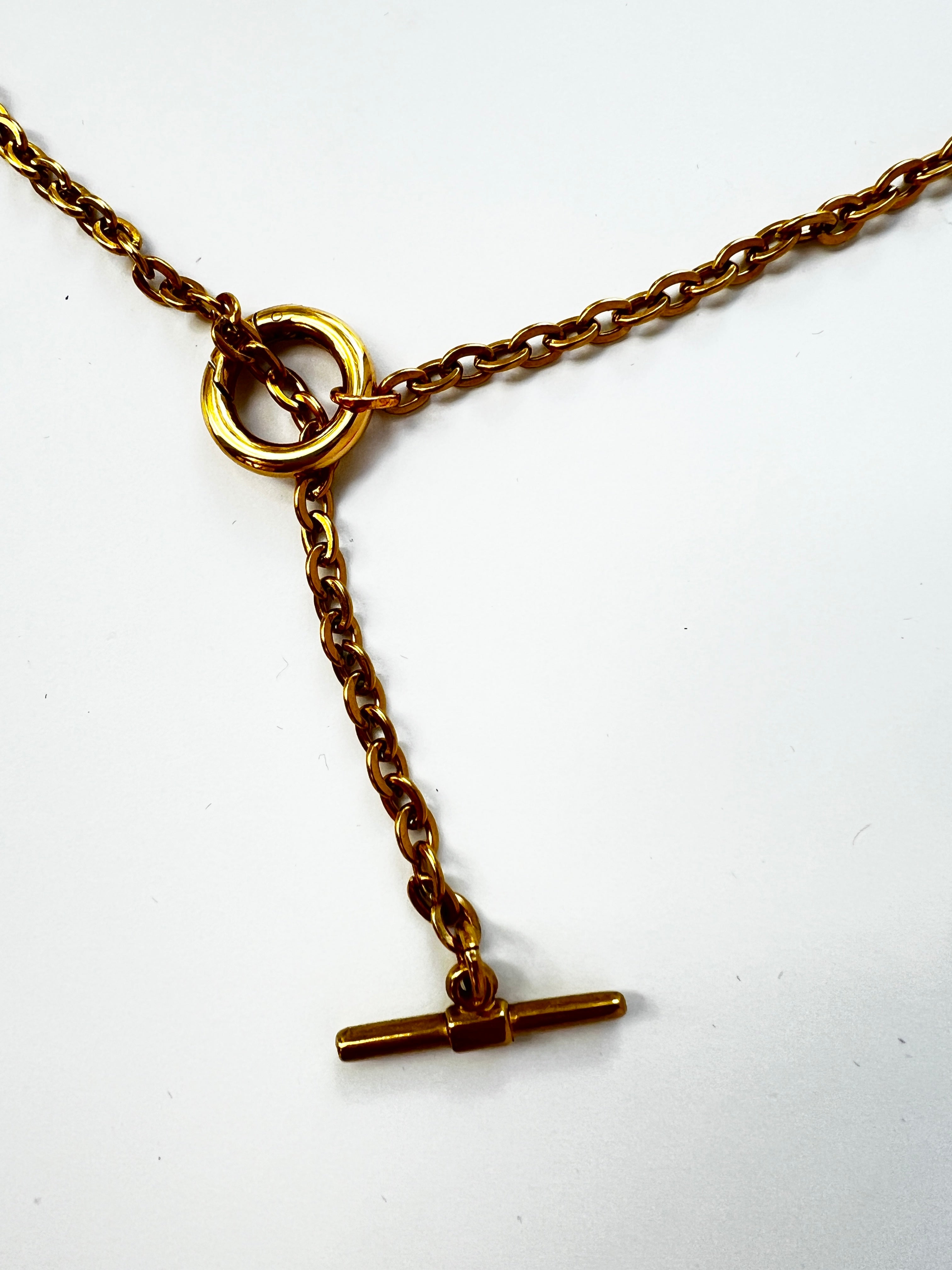 Mova gold tone loop necklace, close-up of the ring and T-bar drop in nickel-free surgical steel – Omasi Collection