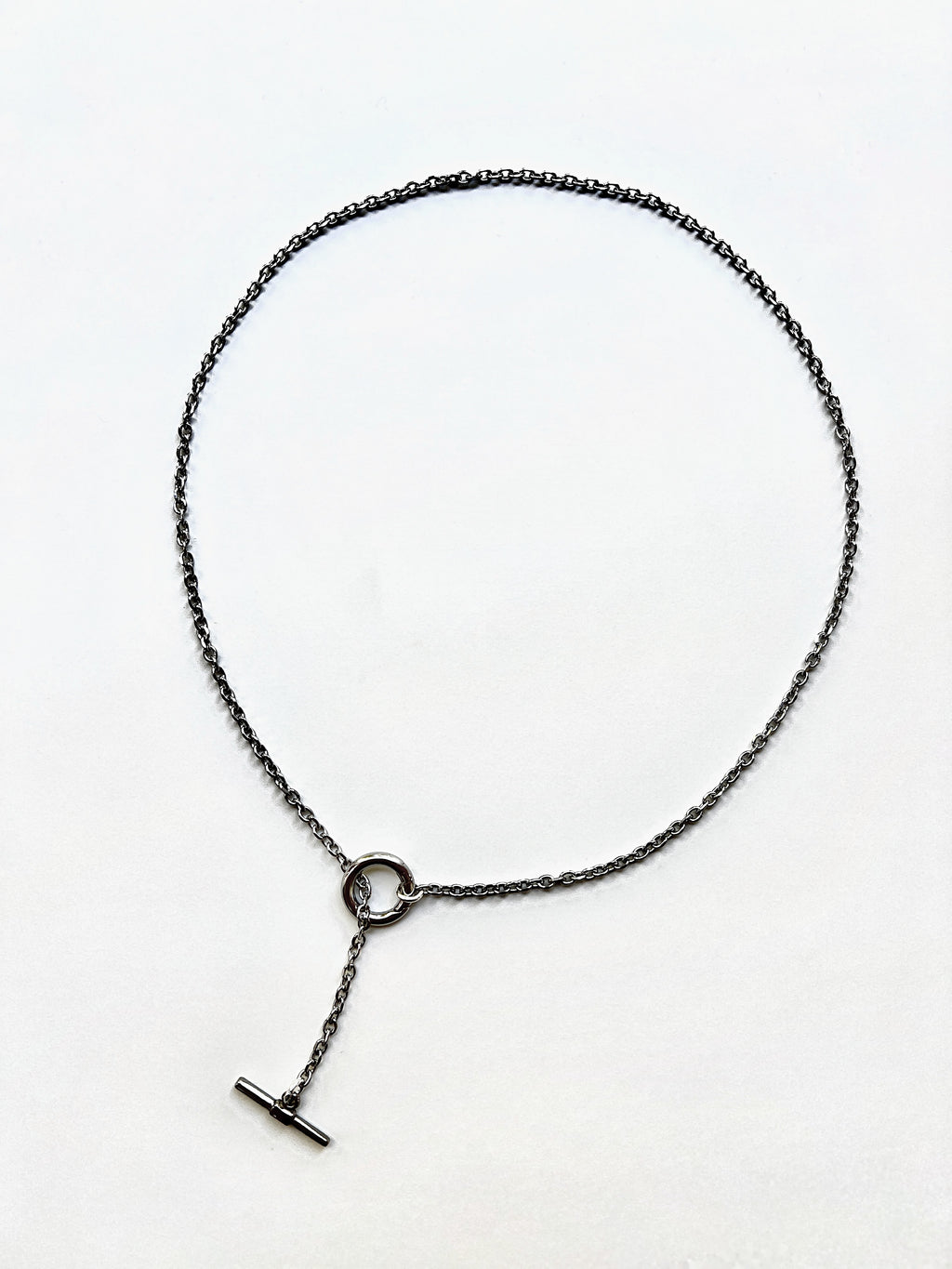 Mova silver tone loop necklace, adjustable T-bar lariat in nickel-free surgical steel, flat lay – Omasi Collection