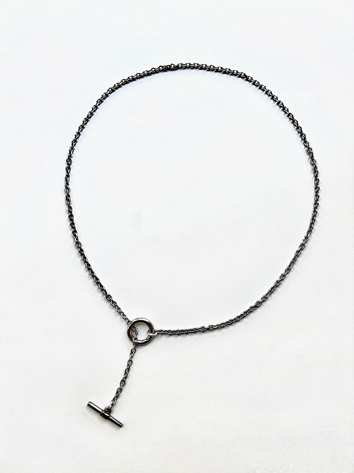 Mova silver tone loop necklace, adjustable T-bar lariat in nickel-free surgical steel, flat lay – Omasi Collection