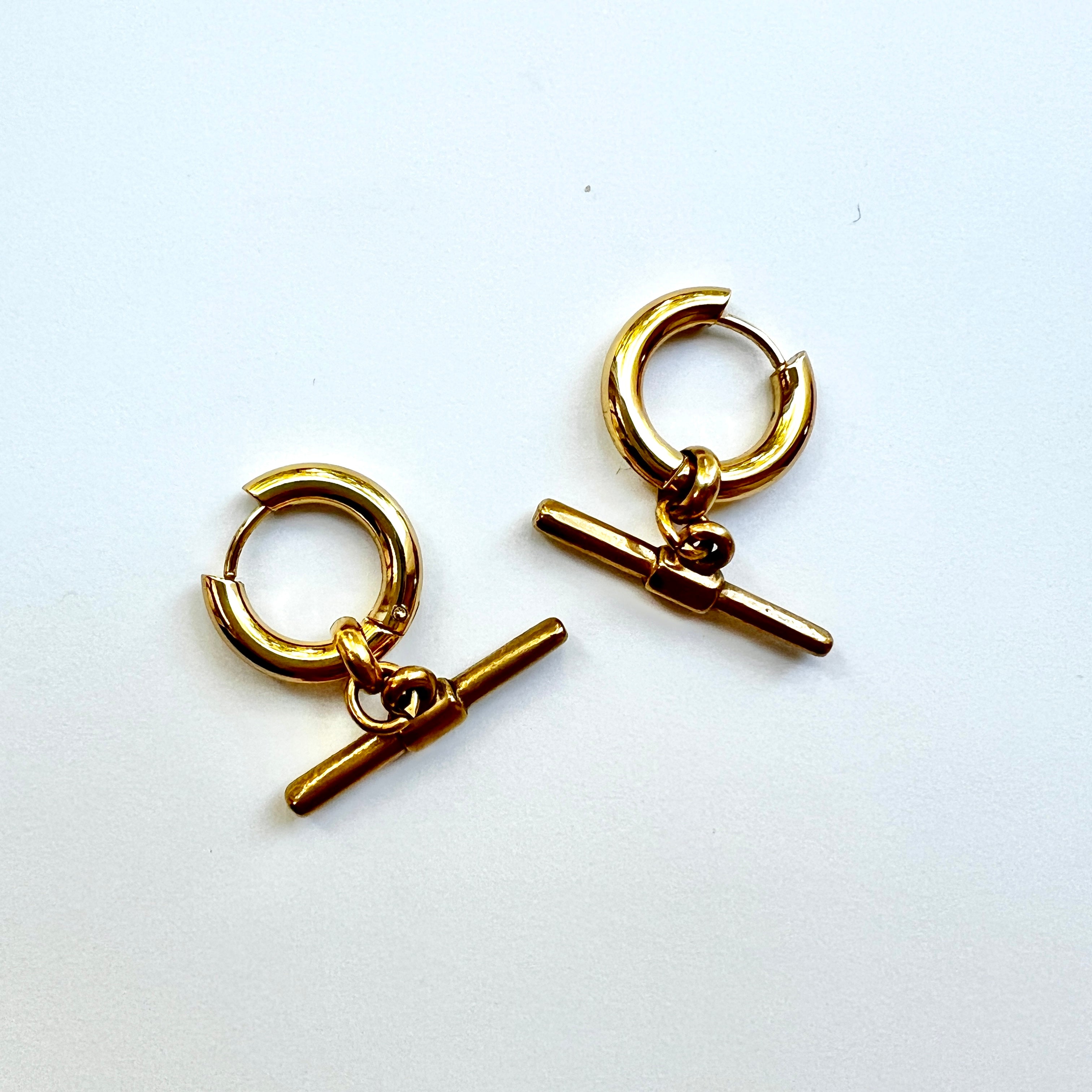 Mova silver tone T-bar hoop earrings in nickel-free surgical steel, flat lay – Omasi Collection