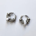 Pair of Omasi Asteria huggie hoop earrings in nickel-free surgical steel, each with a white howlite stone and crystal rings
