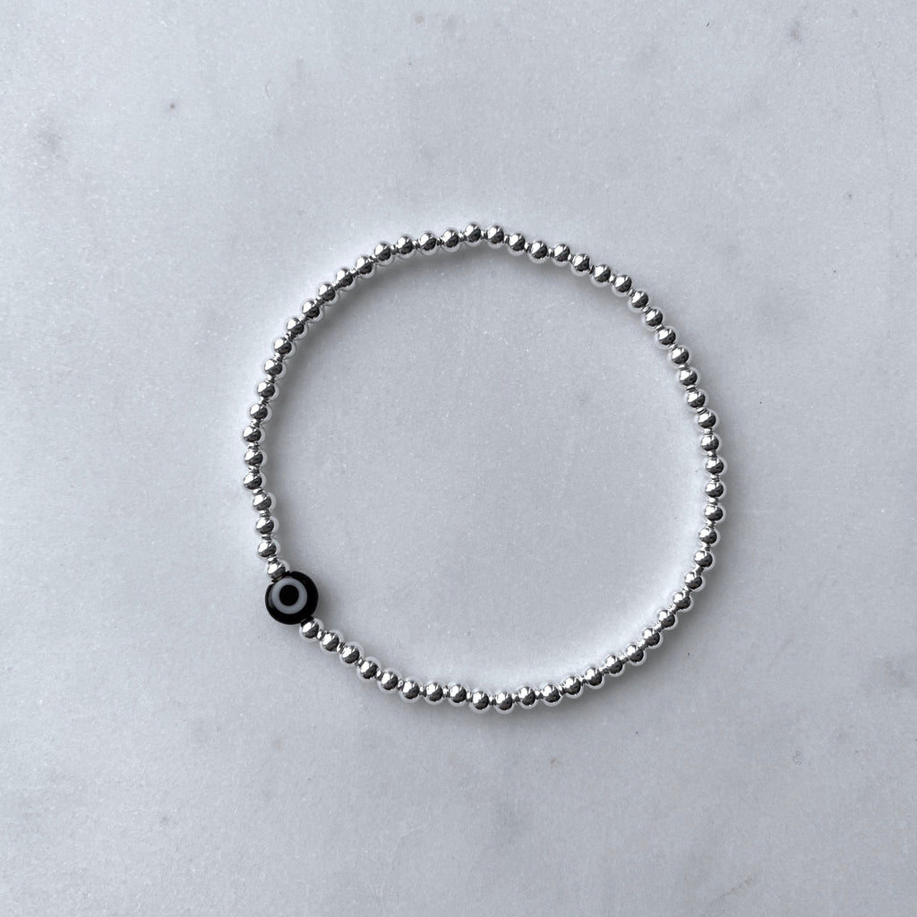 Nazar black evil eye silver bracelet flat lay – Omasi Collection Finland